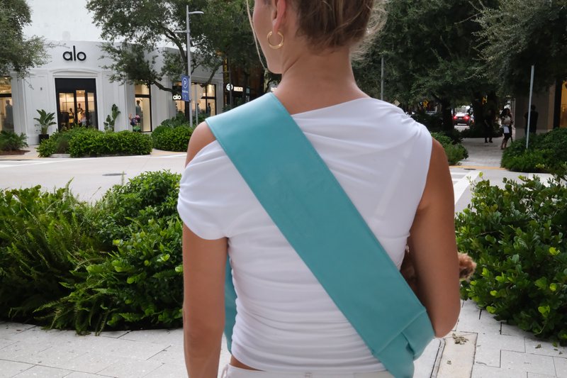 Back view showing the wide flat strap resting across the shoulder and back.
